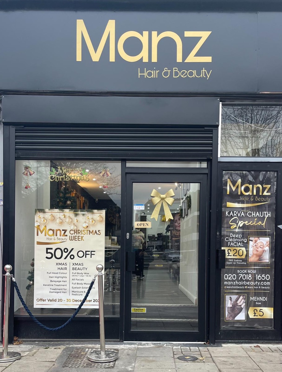 The Manz Hair and Beauty shopfront on Ilford High Road, black frontage with gold lettering