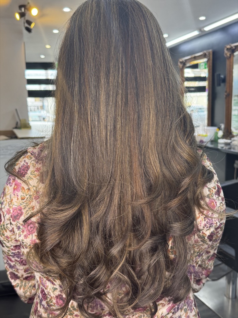 Warm brown balayage with bouncy blow-dried curls at Manz Hair and Beauty