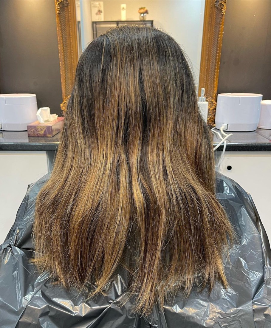 Long brunette hair with caramel ombre and soft curls, finished in the salon