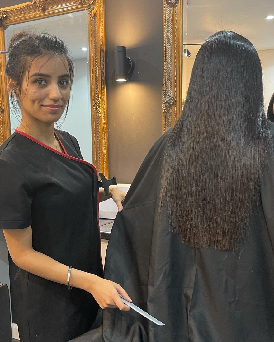 A stylist at Manz Hair and Beauty beside a client with long, glossy, freshly smoothed hair